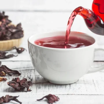 Xícara de chá de hibisco em uma mesa, ilustrando os benefícios do chá para saúde e controle de peso.