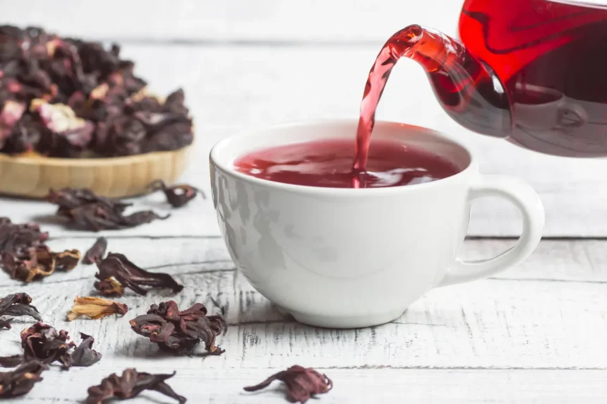 Xícara de chá de hibisco em uma mesa, ilustrando os benefícios do chá para saúde e controle de peso.