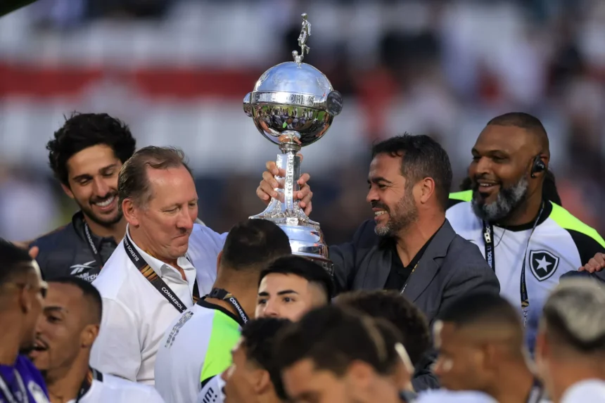 Torcedores do Botafogo celebrando a conquista da Libertadores 2024 com bandeiras e faixas no Monumental de Núñez.