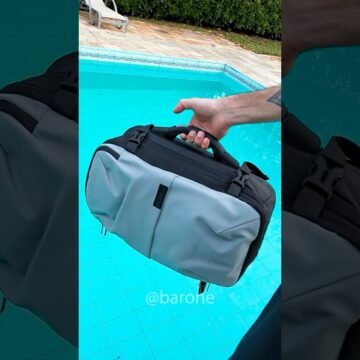 Mochila Buraco Negro aberta, exibindo compartimentos e itens variados dentro, como roupas, notebooks e acessórios, demonstrando a incrível capacidade de armazenamento e a funcionalidade avançada.