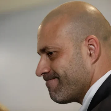 Imagem mostrando o Supremo Tribunal Federal (STF) com uma tornozeleira eletrônica ao fundo, simbolizando a liberdade condicional de Daniel Silveira, e um fundo de balança de justiça.