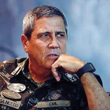 A imagem mostra o general Braga Netto, vestido com uniforme militar, sendo escoltado por agentes da Polícia Federal após sua prisão, no bairro de Copacabana.