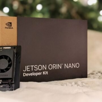 Um pequeno computador da Nvidia, o Jetson Orin Nano Super, em cima de uma mesa, mostrando suas portas de conexão e tamanho compacto, com um fundo que sugere um ambiente de laboratório ou sala de aula.