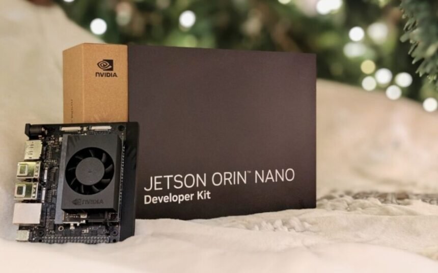 Um pequeno computador da Nvidia, o Jetson Orin Nano Super, em cima de uma mesa, mostrando suas portas de conexão e tamanho compacto, com um fundo que sugere um ambiente de laboratório ou sala de aula.