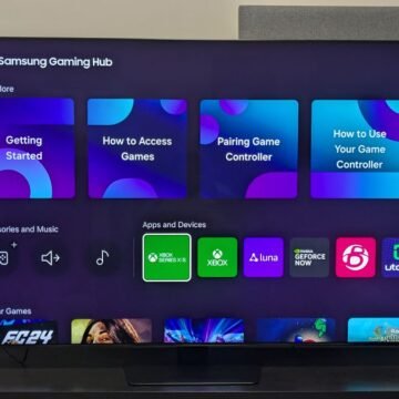 Imagem de uma TV Samsung moderna exibindo a interface One UI na tela, com ícones organizados e um design intuitivo.