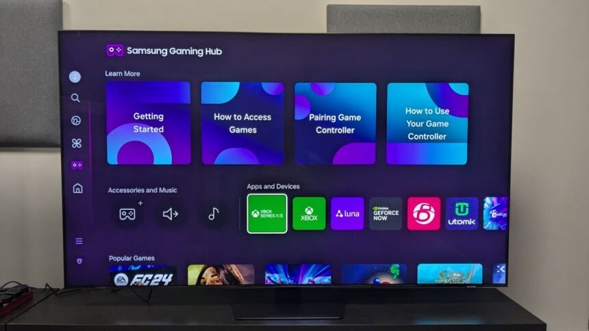 Imagem de uma TV Samsung moderna exibindo a interface One UI na tela, com ícones organizados e um design intuitivo.