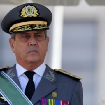 Braga Netto sendo escoltado por agentes da Polícia Federal em frente a um prédio em Copacabana, com viaturas ao fundo.