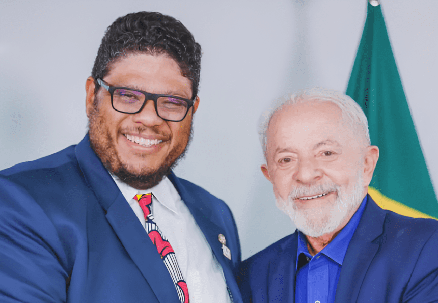 Imagem de Alexandre Brasil Fonseca ao lado do presidente Lula, em um evento público, mostrando um sorriso e proximidade.