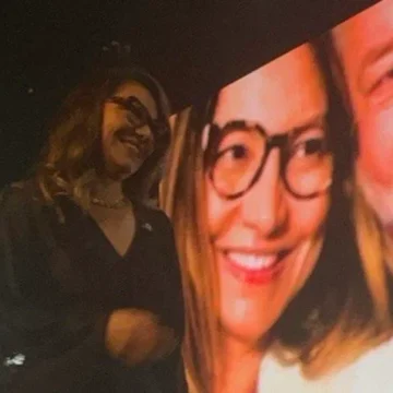 Primeira-dama Janja discursando em evento na Casa Natura, com decoração sofisticada e público alinhado ao governo.