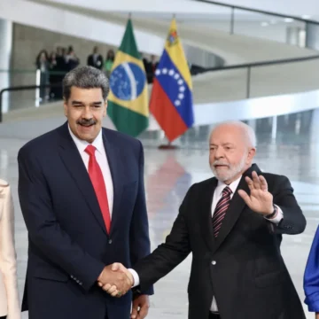Reunião entre os presidentes Lula do Brasil e Nicolás Maduro da Venezuela durante encontro da Unasul em Brasília, onde ambos estão sentados em uma mesa, conversando.