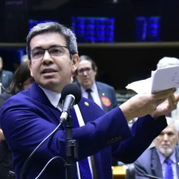 O senador Randolfe Rodrigues em pose séria, olhando para a câmera em um ambiente formal.