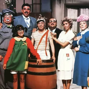 Imagem colorida da vila do Chaves com todos os personagens reunidos em frente à escadaria, com um ar nostálgico e divertido.