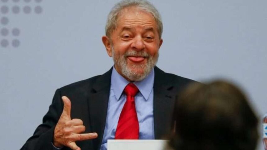 Lula sorrindo em um evento, segurando um papel com o logo do governo.